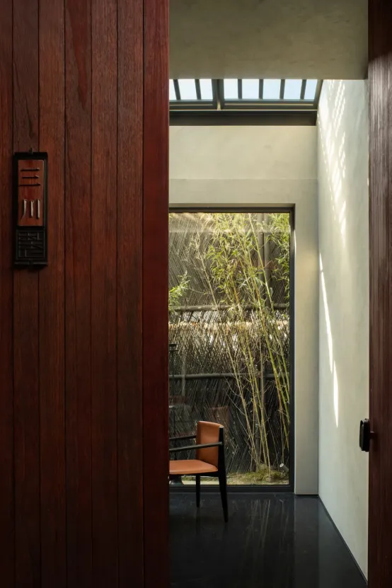 Cozy room with wooden walls and floors, featuring two chairs and a potted plant, creating a warm atmosphere