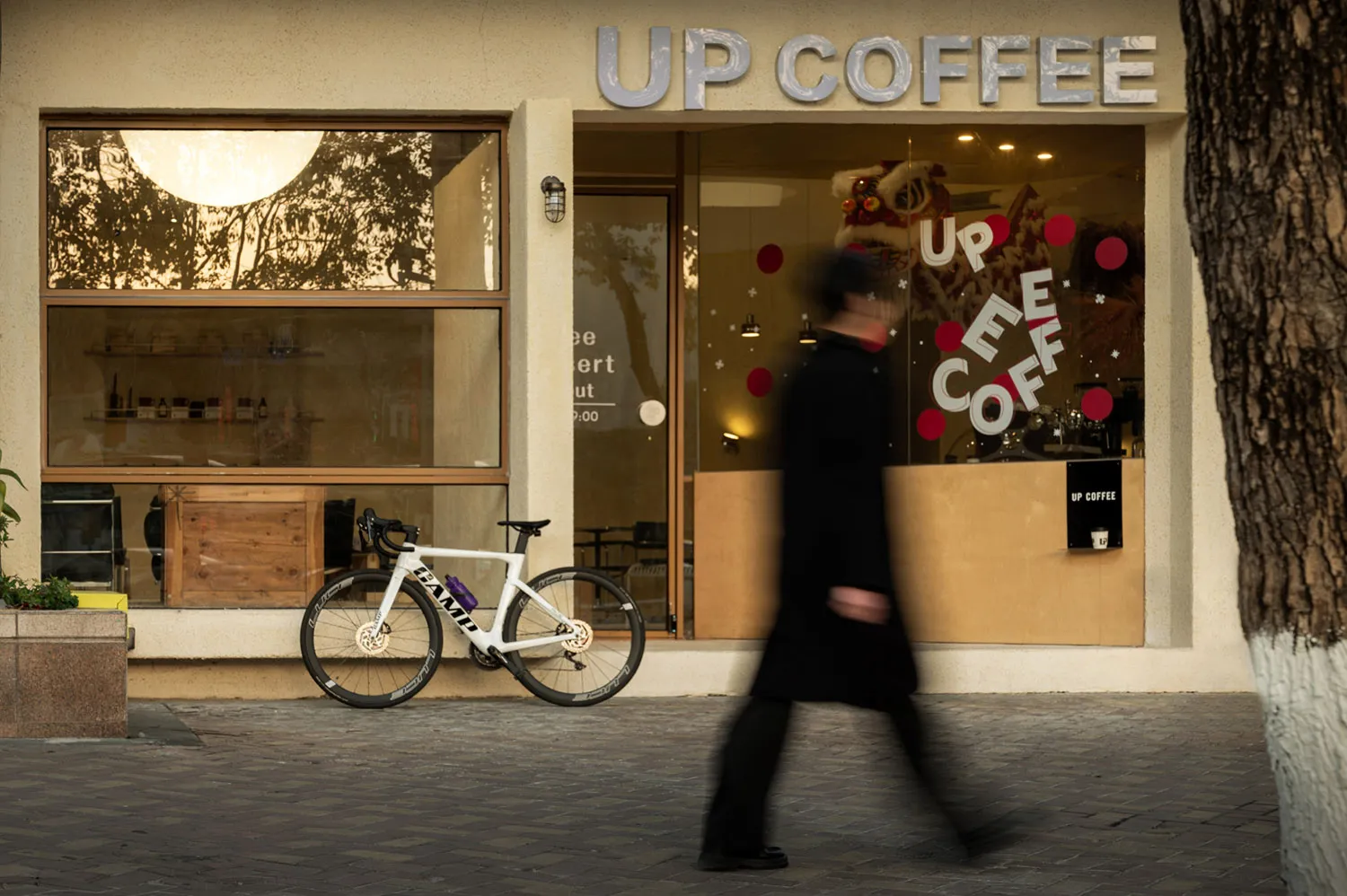 A casual coffee shop with comfortable seating, bicycles parked outside, and a welcoming atmosphere
