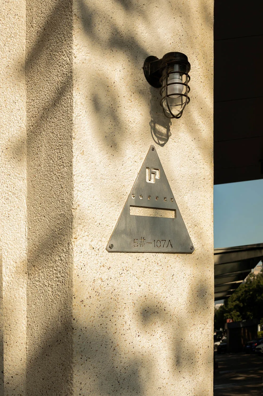 A building with a metal triangle sign and a brick exterior, conveying a sense of urban architecture and functionality