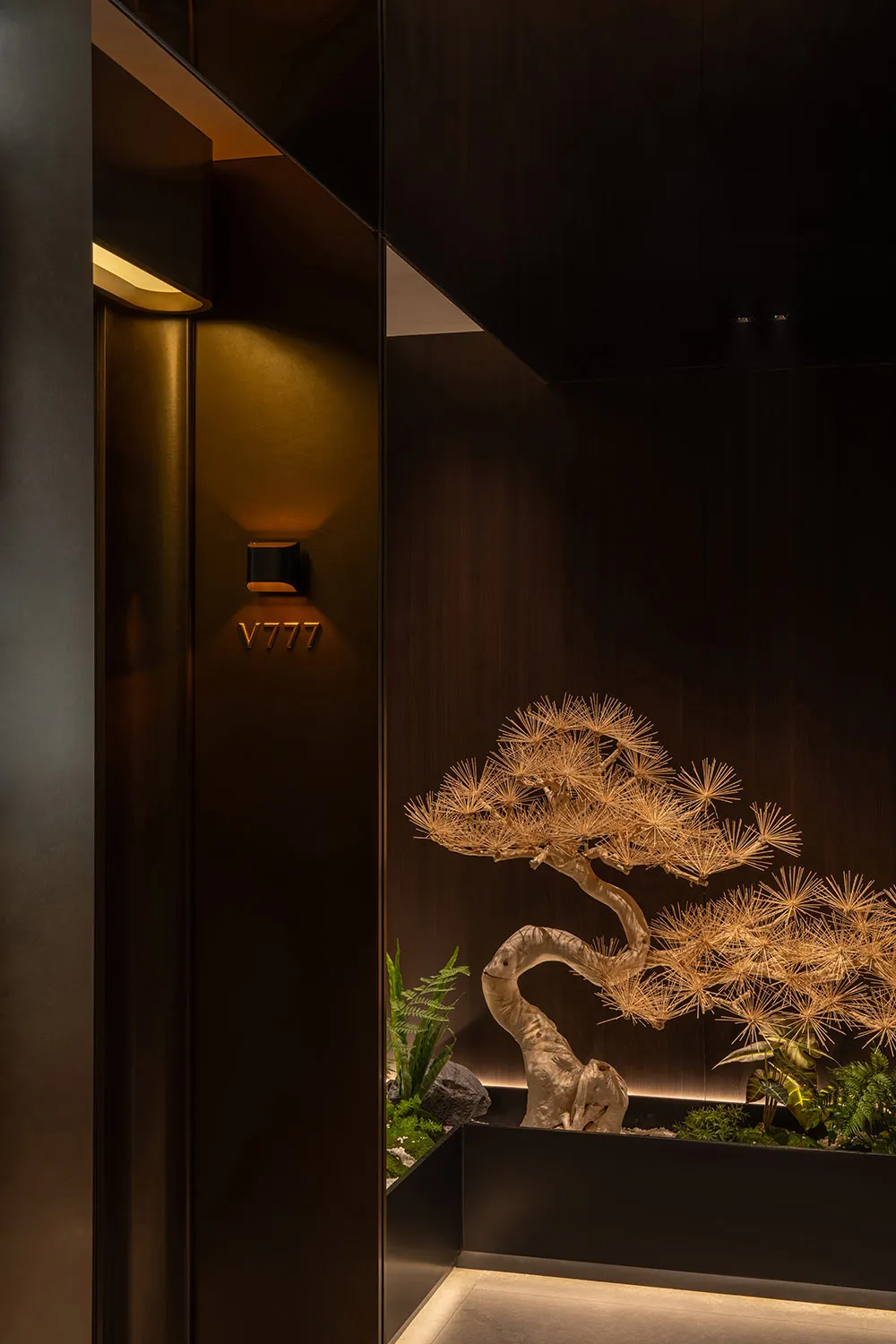 A warm and inviting living space with a large wooden tree sculpture as a centerpiece, placed in front of a doorway