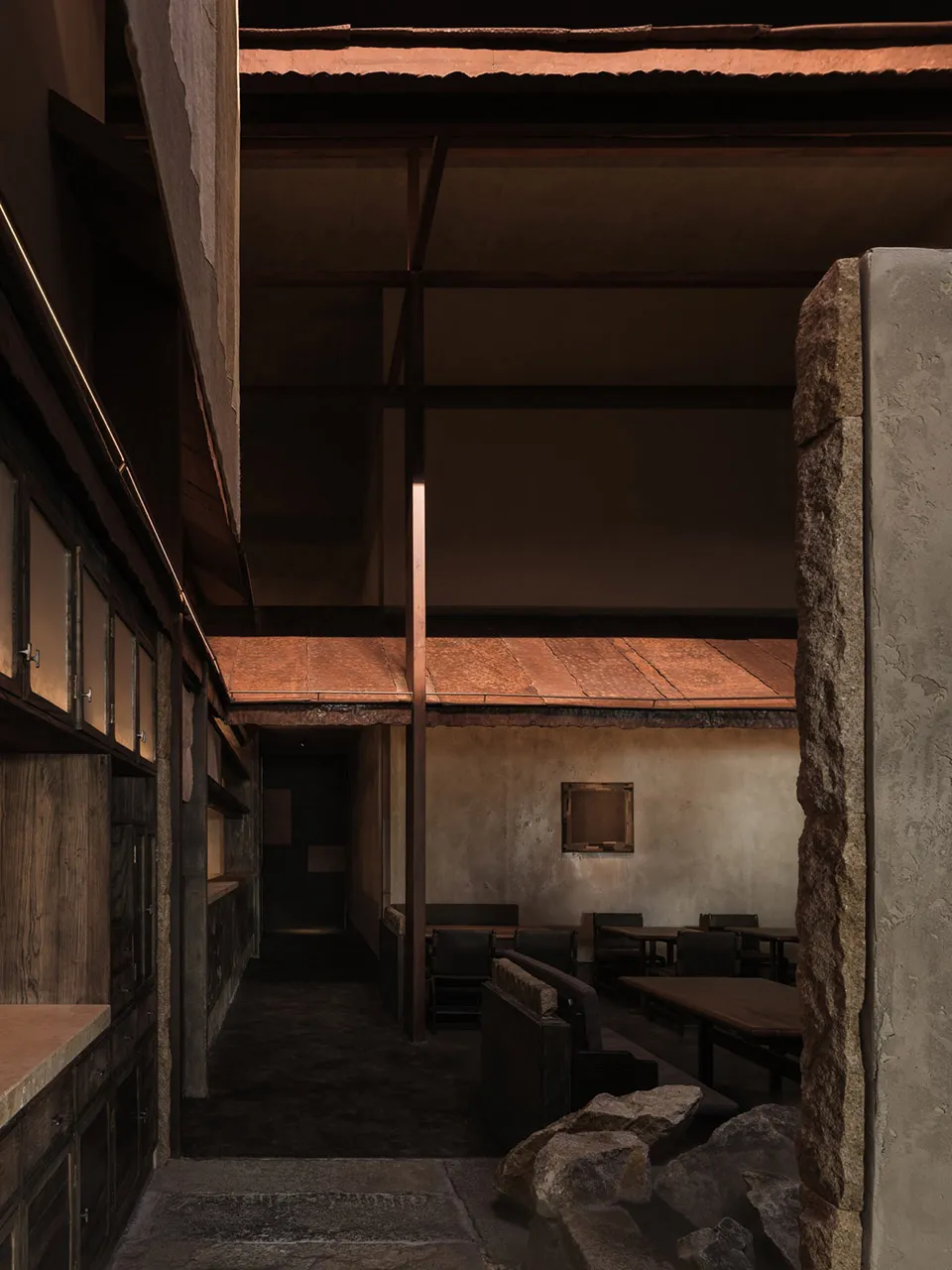a modern restaurant interior with a dining area, bar, and dim lighting