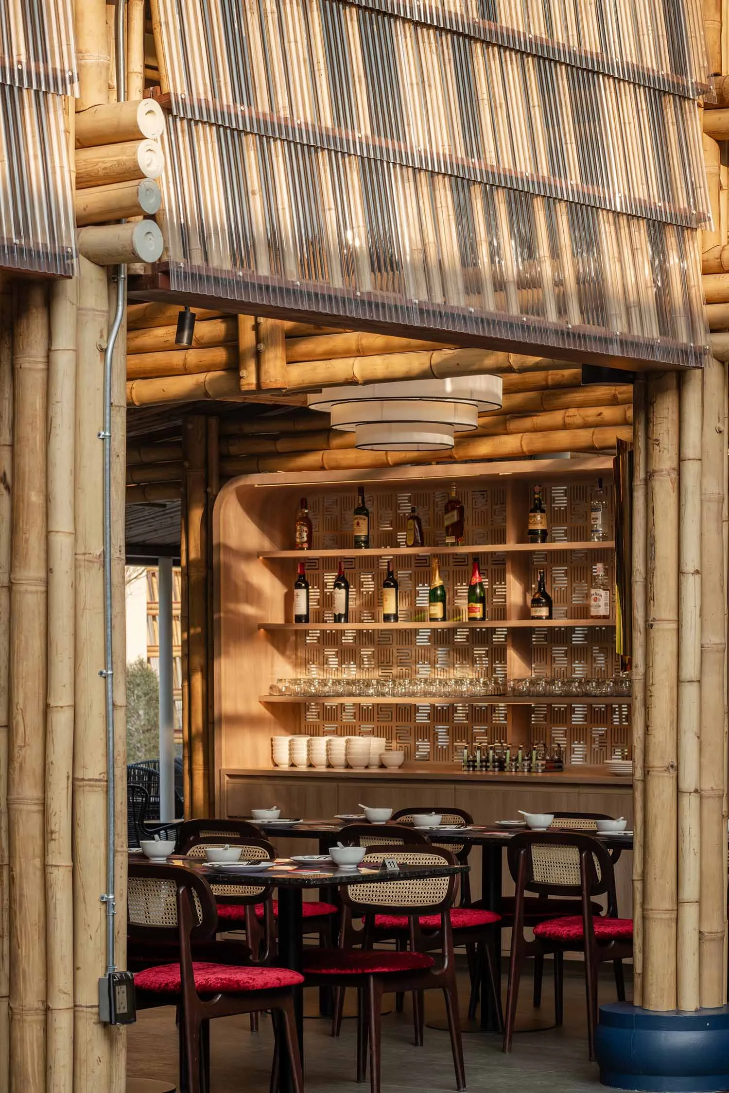Warm and inviting Asian restaurant bar with a wooden shelf, wine glasses, and bamboo elements