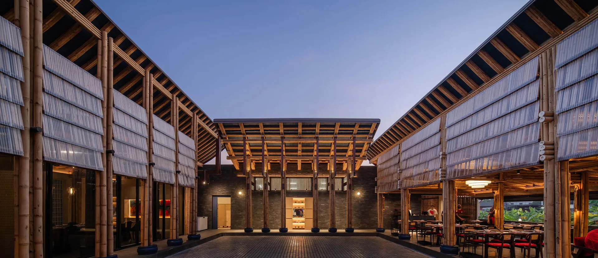 A classic building with a brick exterior and an open seating area with benches, surrounded by a pleasant atmosphere