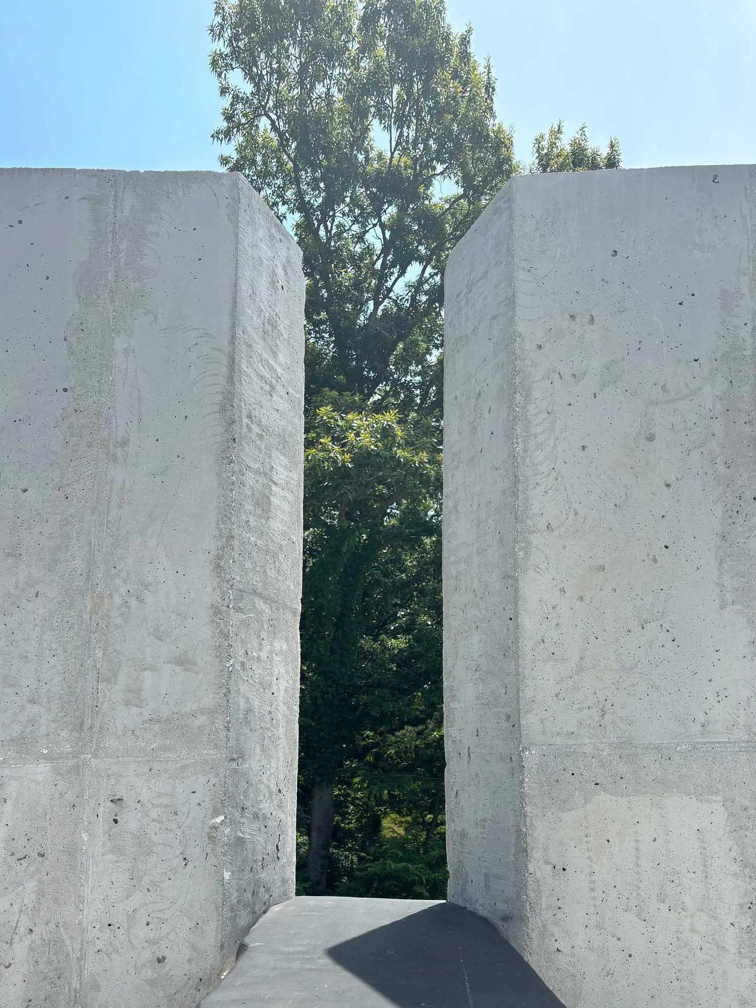 A minimalist architectural scene featuring two large concrete pillars as part of a building's facade, with a focus on structural aspects