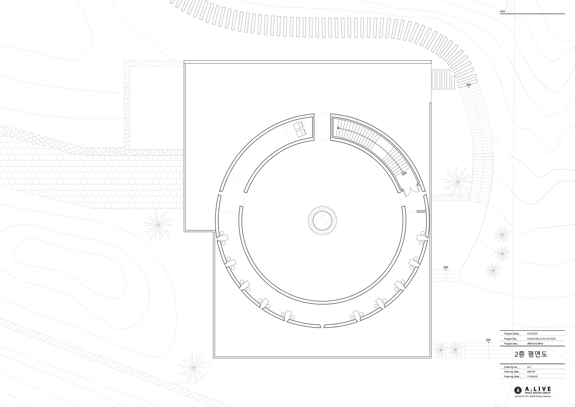 Empty modern building with a circular design on its side, featuring a large circular element in one corner, with ample natural light