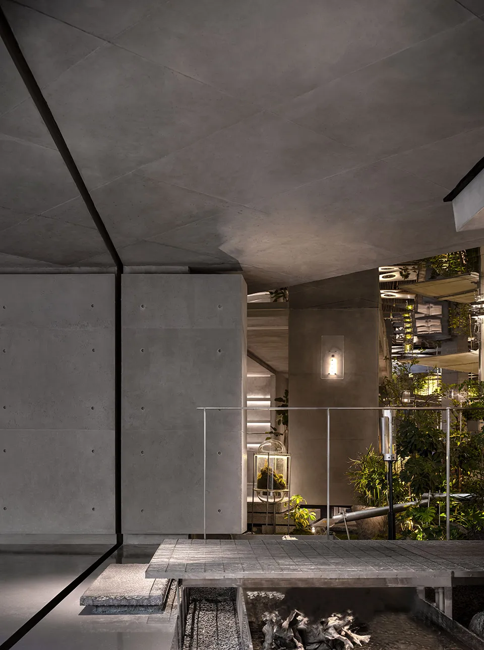 Modern building with a large glass wall, potted plants, and a mix of concrete and metal elements, emphasizing openness and natural light