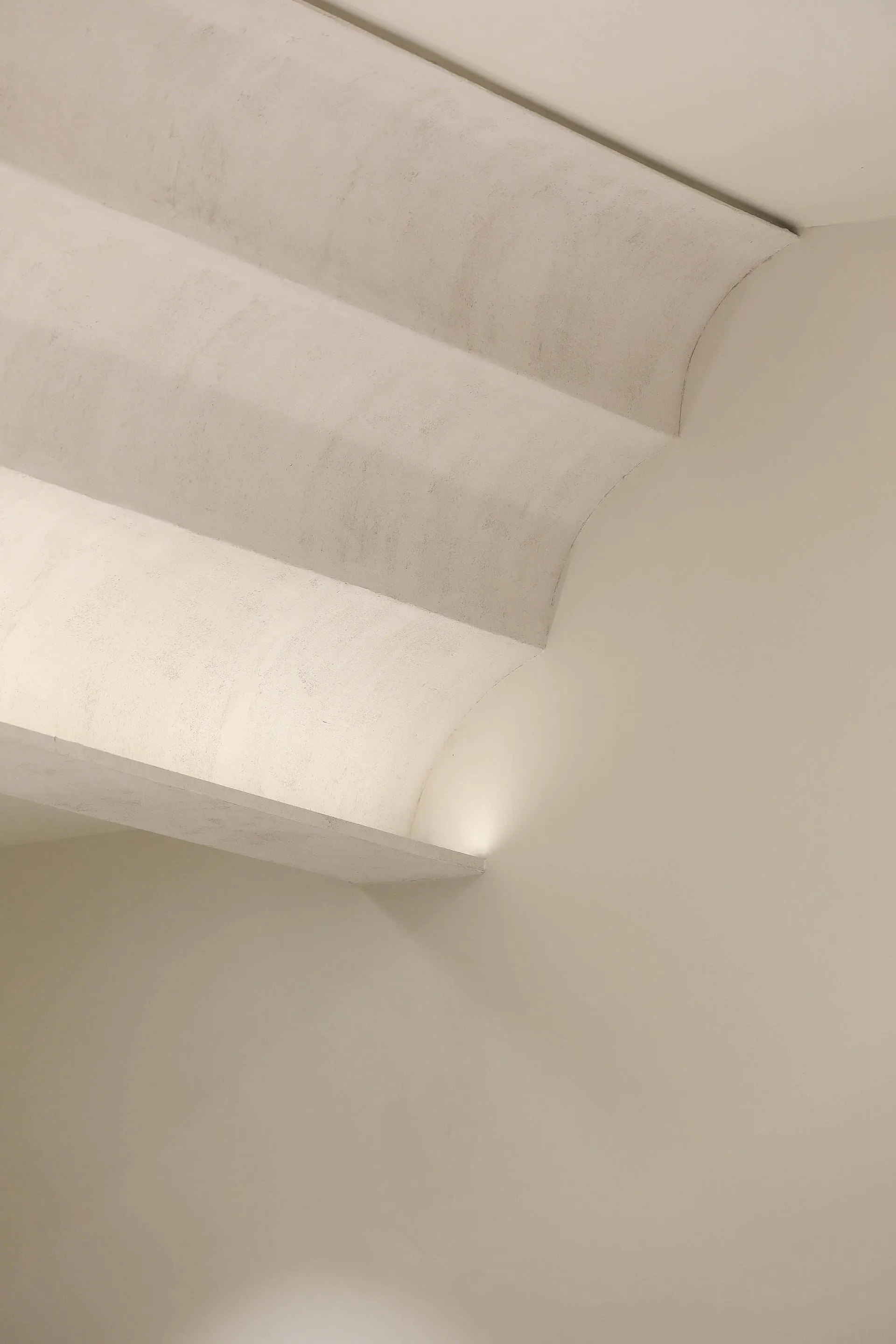 A photo of a staircase in a white building with concrete stairs and a minimalist design