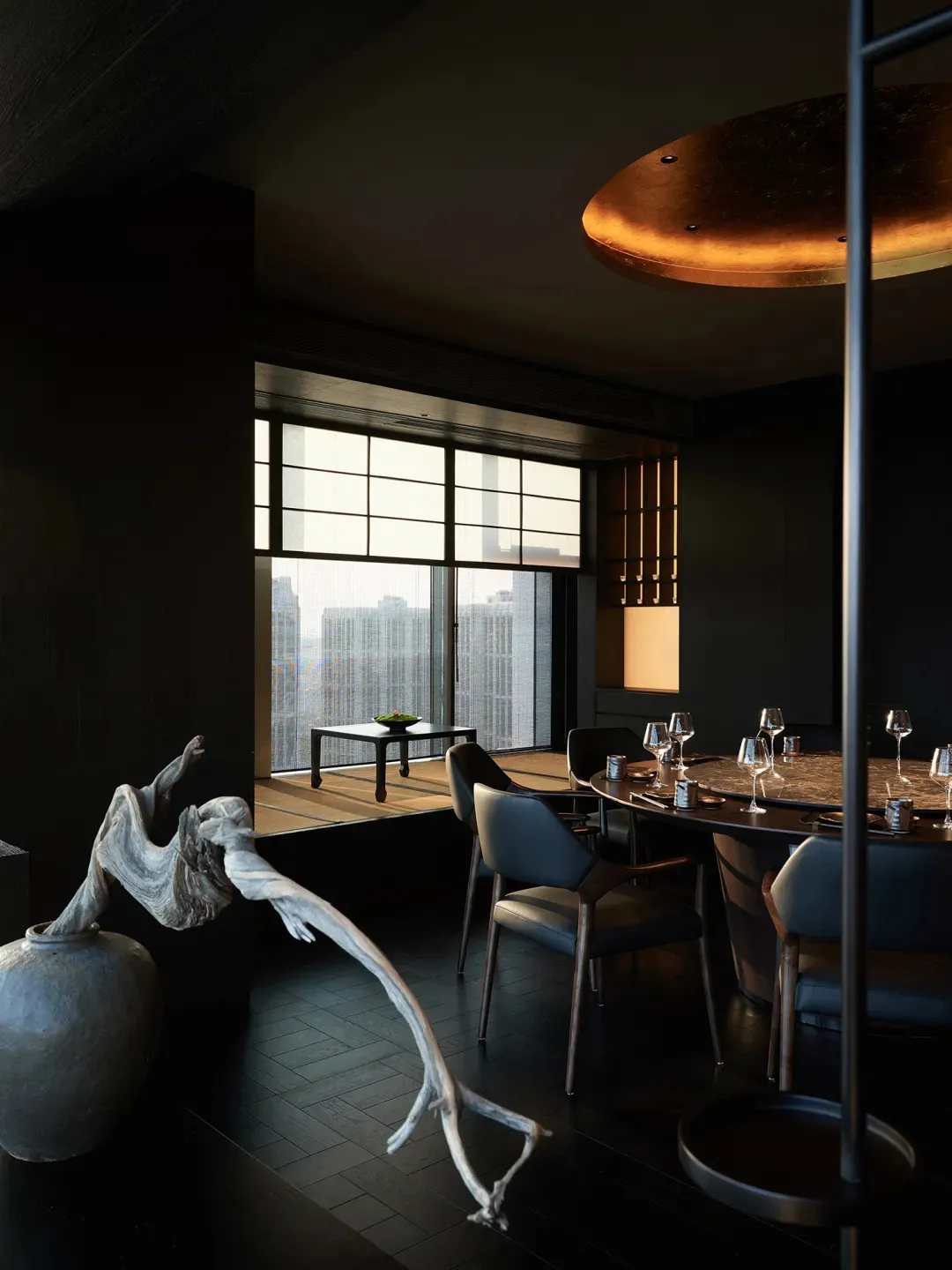 Elegant dining space with a large window, table set with fine china and wine glasses, and multiple chairs for guests