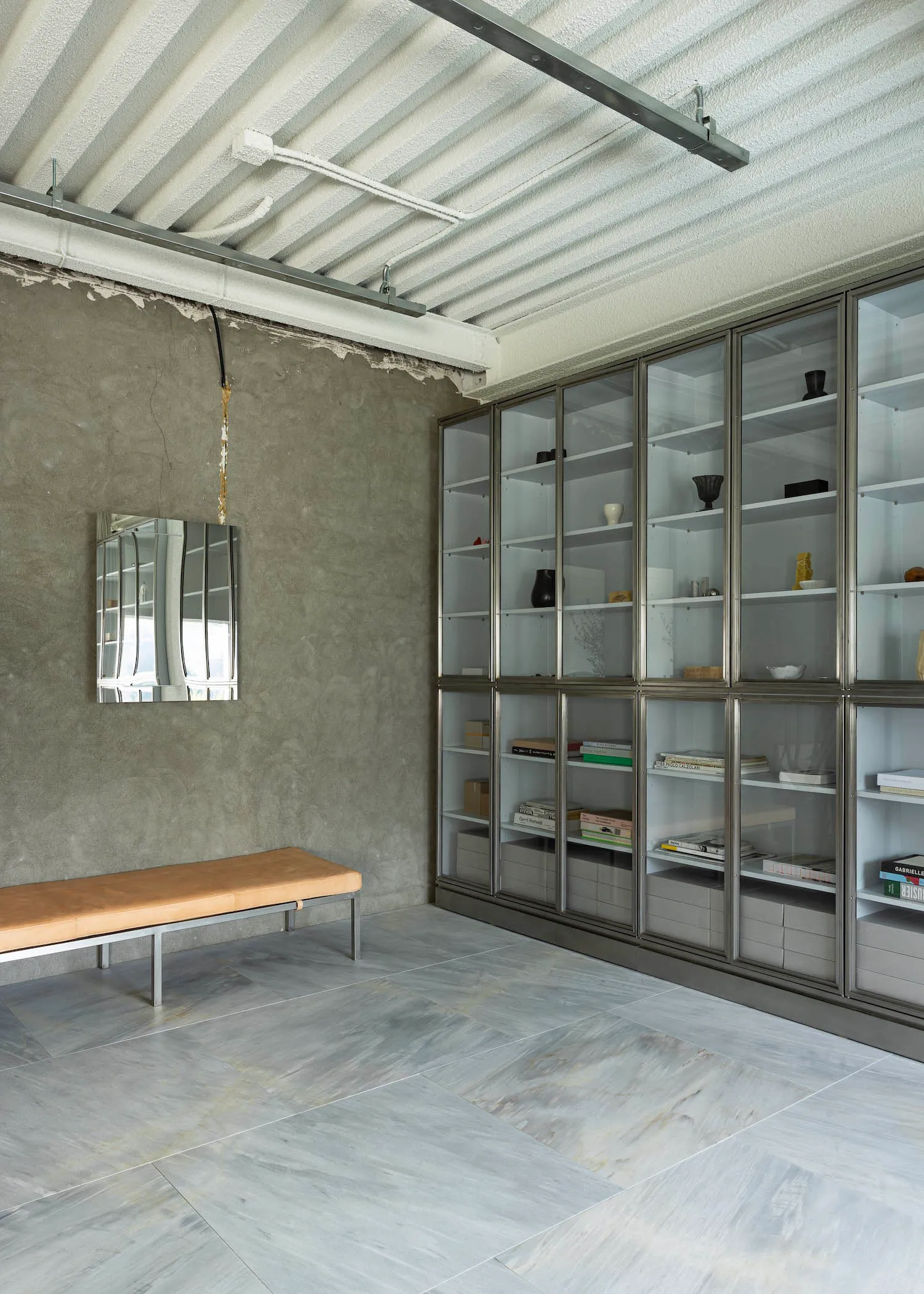 A modern bookshelf with glass shelves and decorative bowls, creating an inviting atmosphere for reading and relaxation