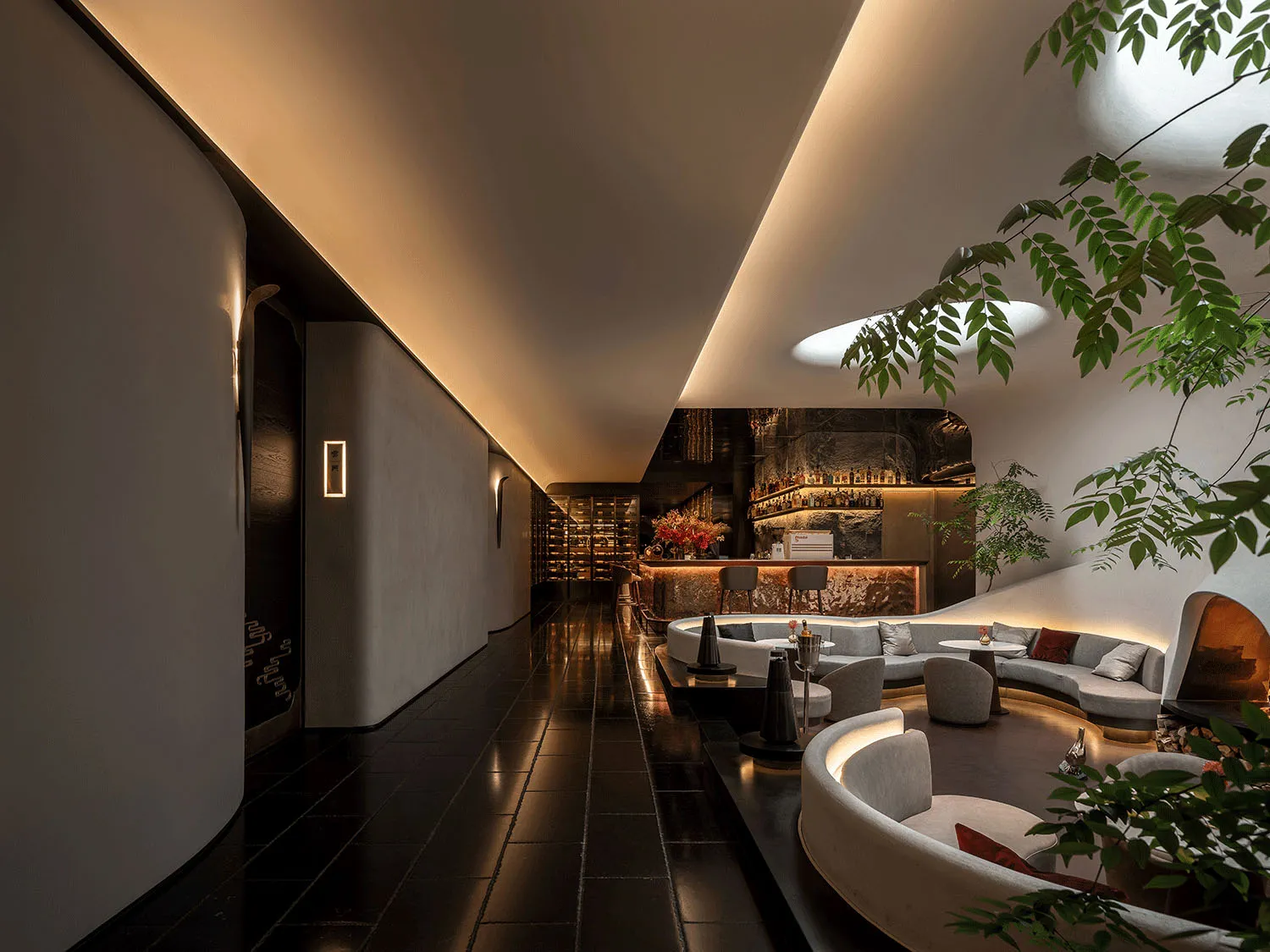 Upscale lounge area with curved design, modern furniture, and potted plants, creating a sophisticated and inviting atmosphere