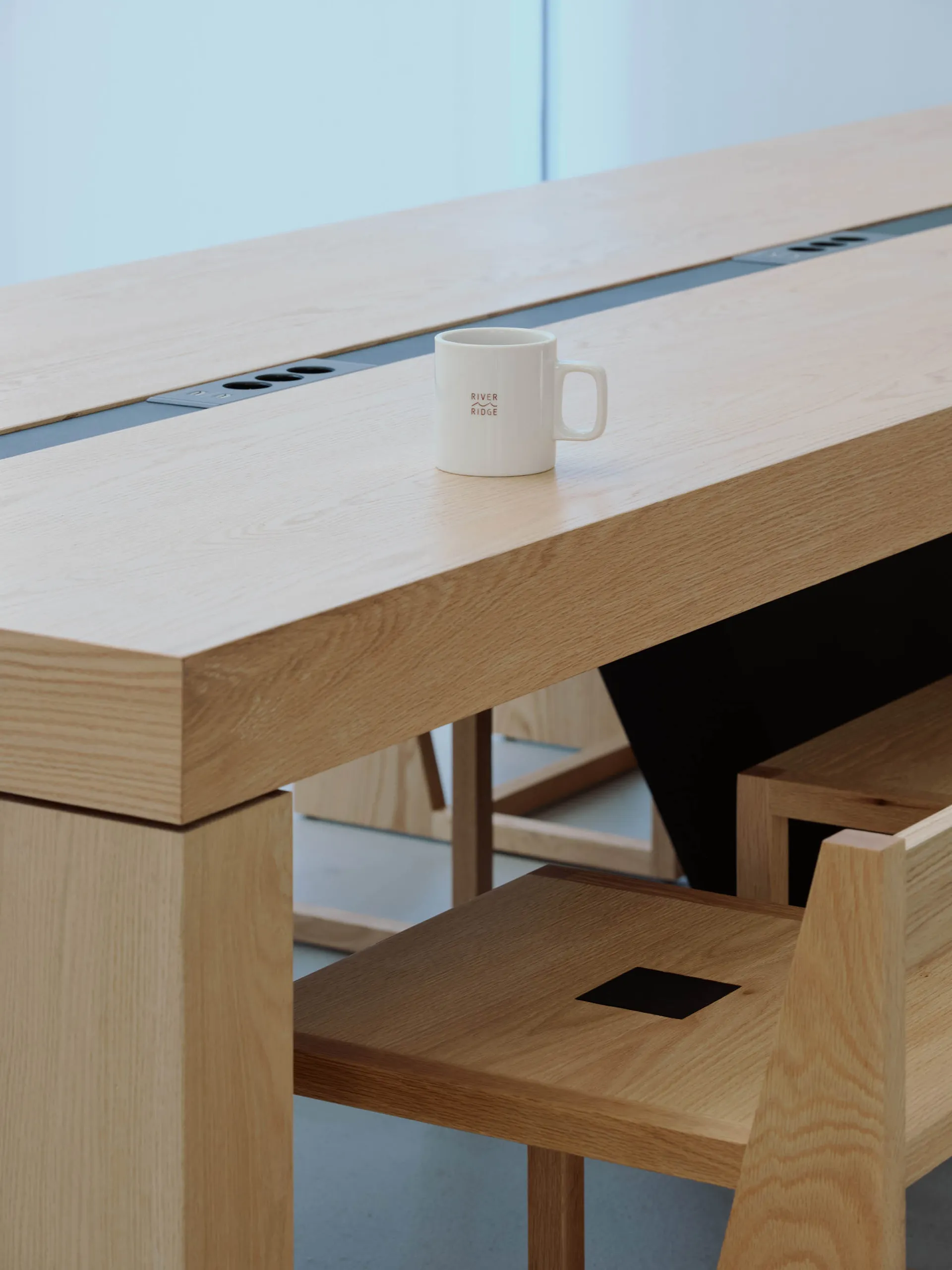 A wooden dining table with a coffee cup and two chairs in a warm and inviting space