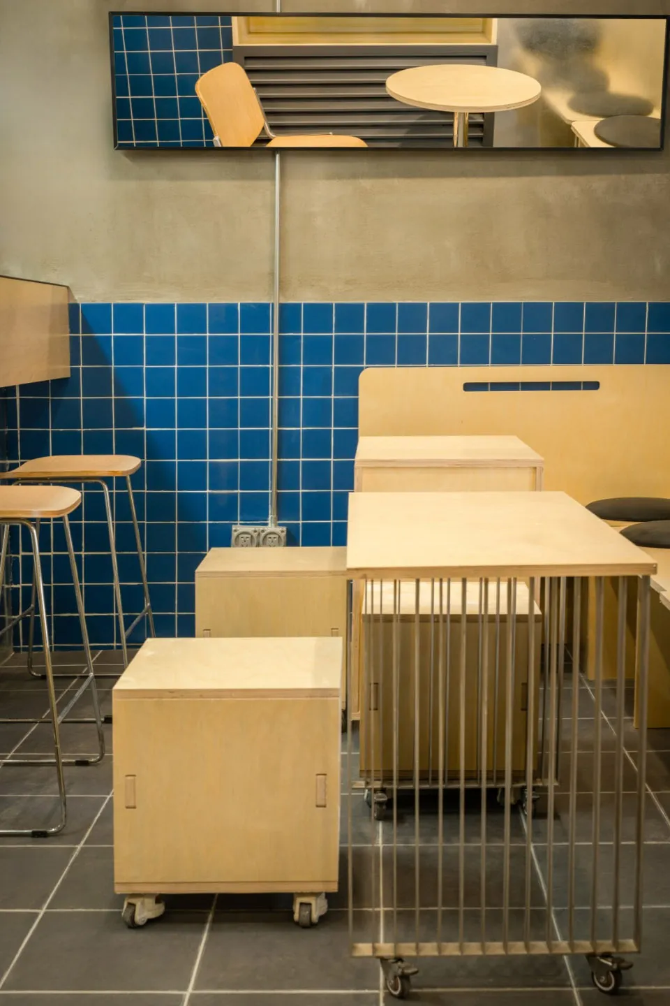 Modern interior space with wooden tables, metal accents, and a unique tile pattern on the walls