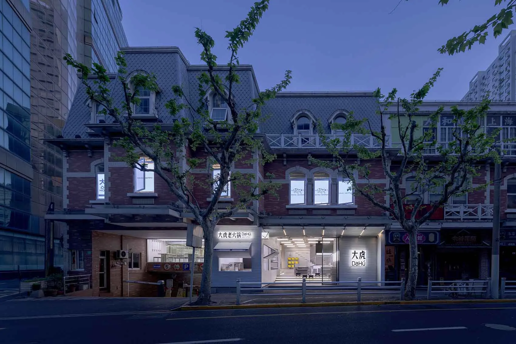 A modern Asian restaurant with large windows, second-story windows, and a city view with trees outside