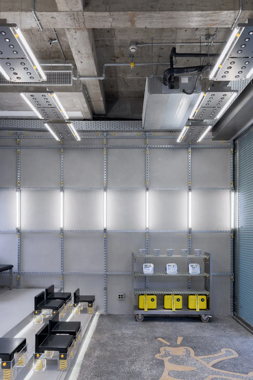 Industrial space with a concrete wall, metal beams, and functional furniture, giving a utilitarian atmosphere