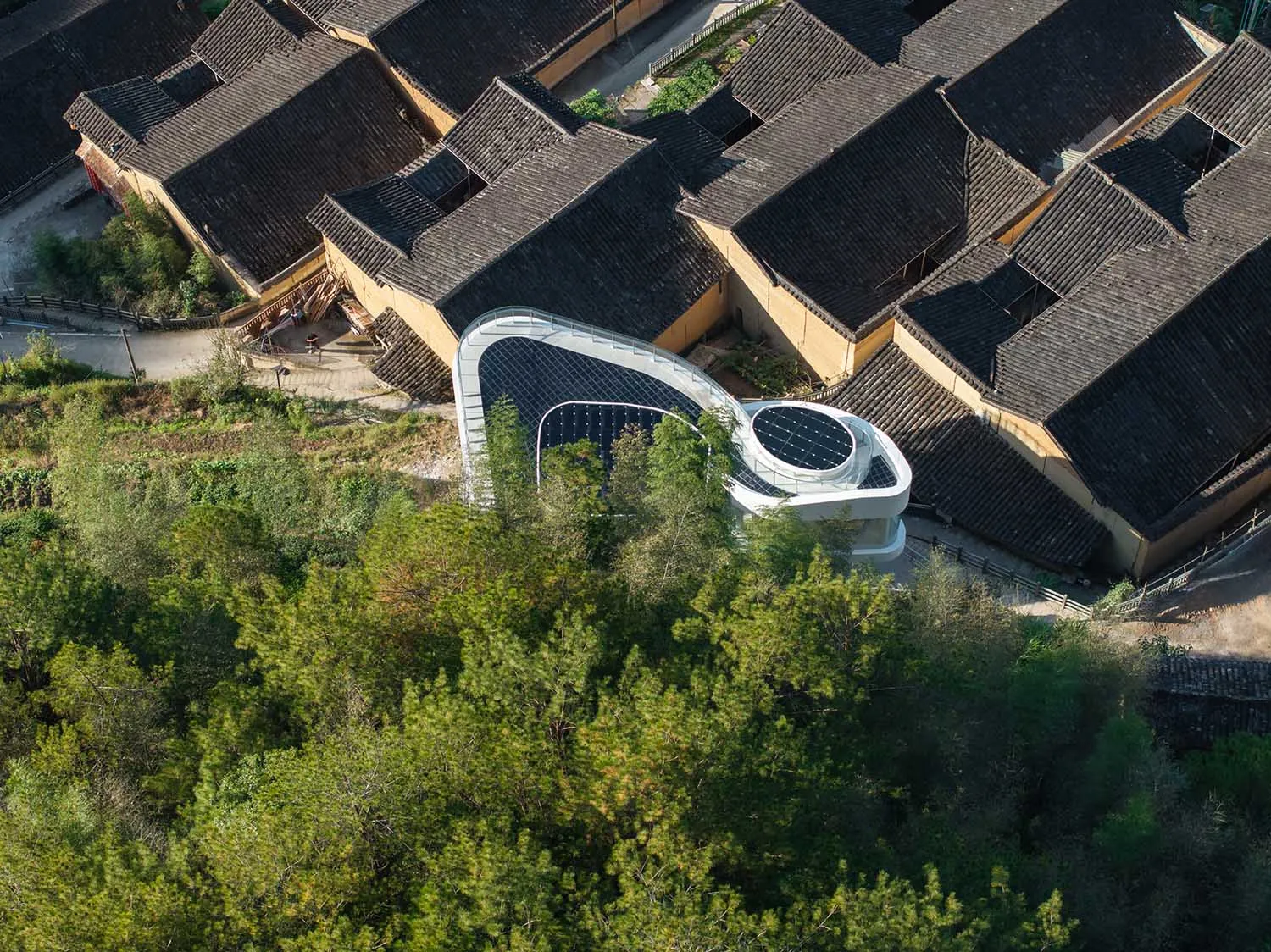 A building with a mix of traditional and modern elements, surrounded by trees, with a bright and inviting atmosphere