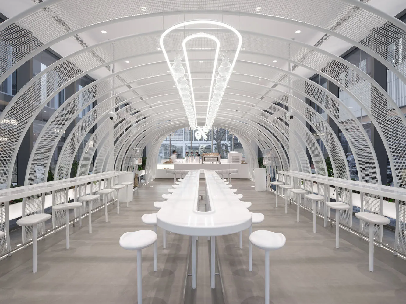 A bright and inviting dining area with multiple white tables and chairs, designed for social gatherings or events