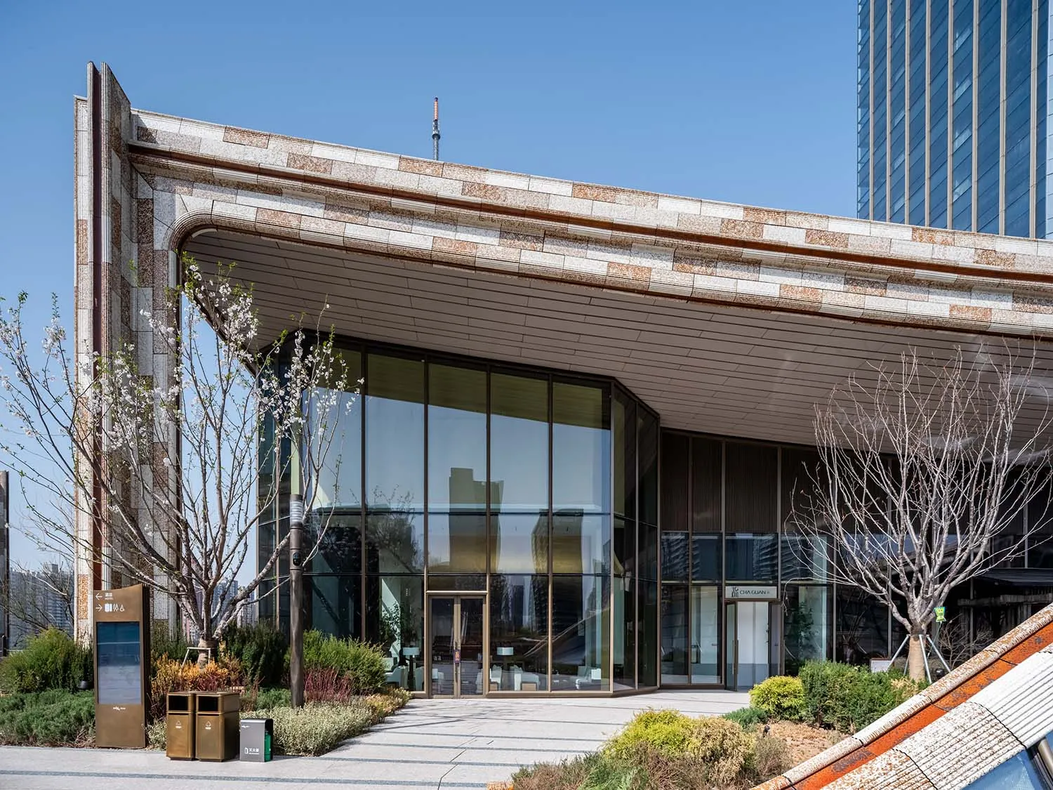 A modern building with a mix of concrete, glass, and wood materials, featuring clean lines and minimalistic design, with natural sunlight coming through the windows