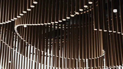A room with a circular arrangement of wooden beams and columns creating a warm and natural atmosphere