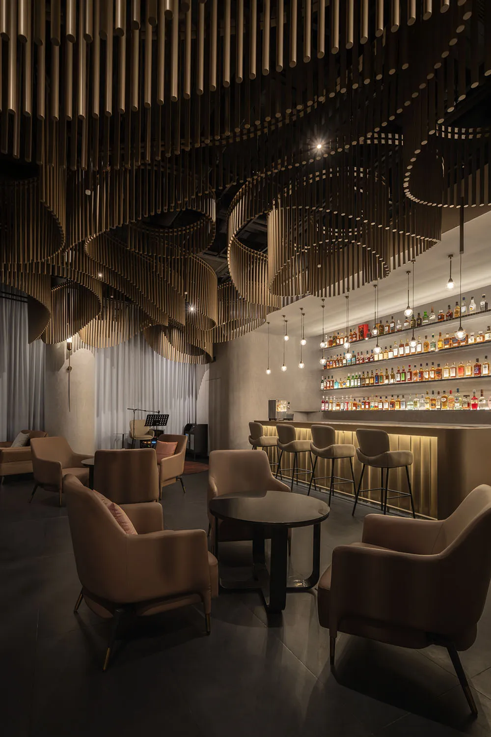 A casual bar area with a counter and chairs, bottles on display, and a relaxed atmosphere