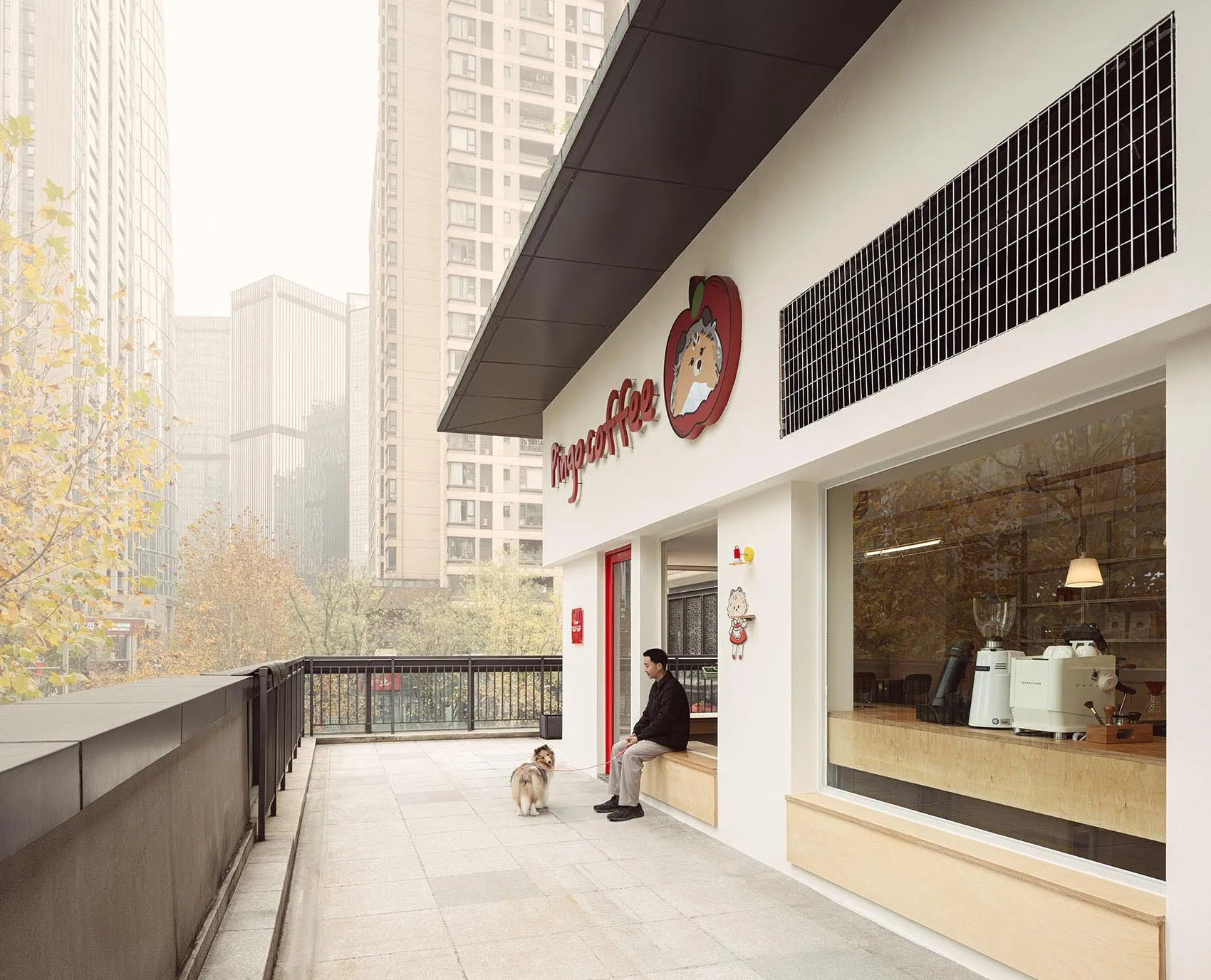 A casual coffee shop exterior with a red awning, large window, and natural light, featuring a man and two dogs outside