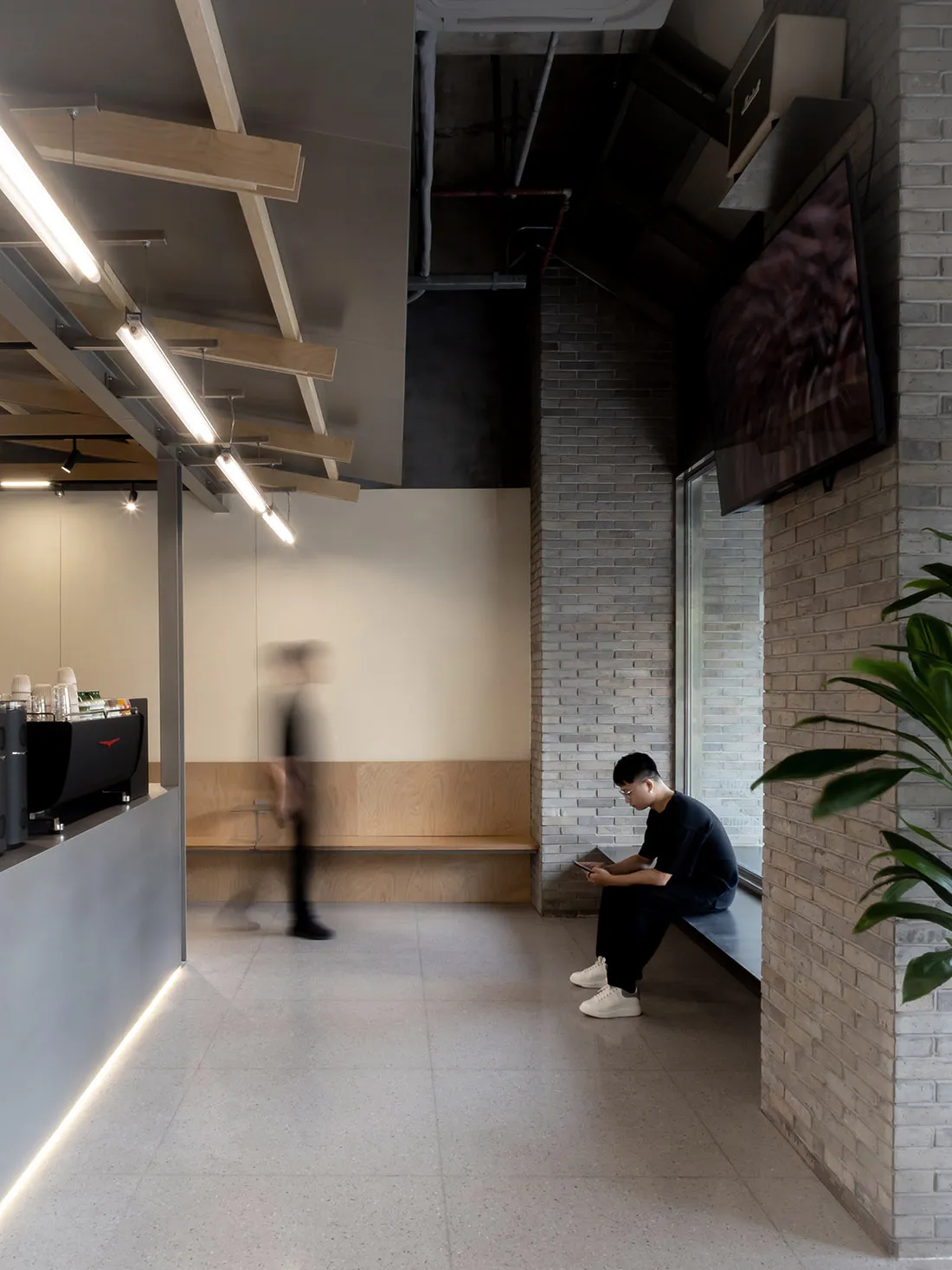 輕鬆的餐廳與客廳區域，配有長椅、盆栽、餐桌與椅子，採用木頭與石材