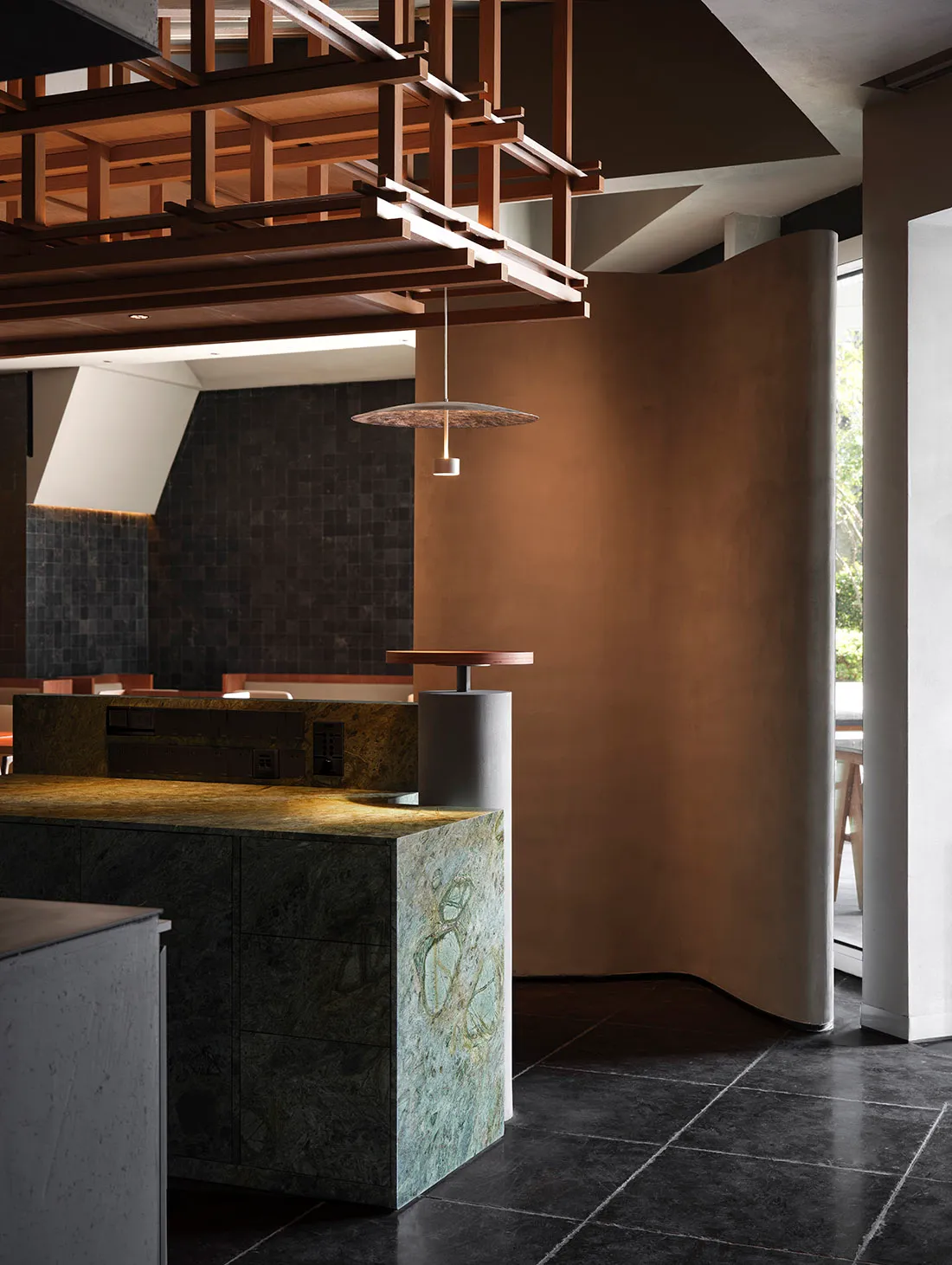 Modern restaurant dining area with a marble countertop, chairs, and a dining table, featuring warm and inviting lighting