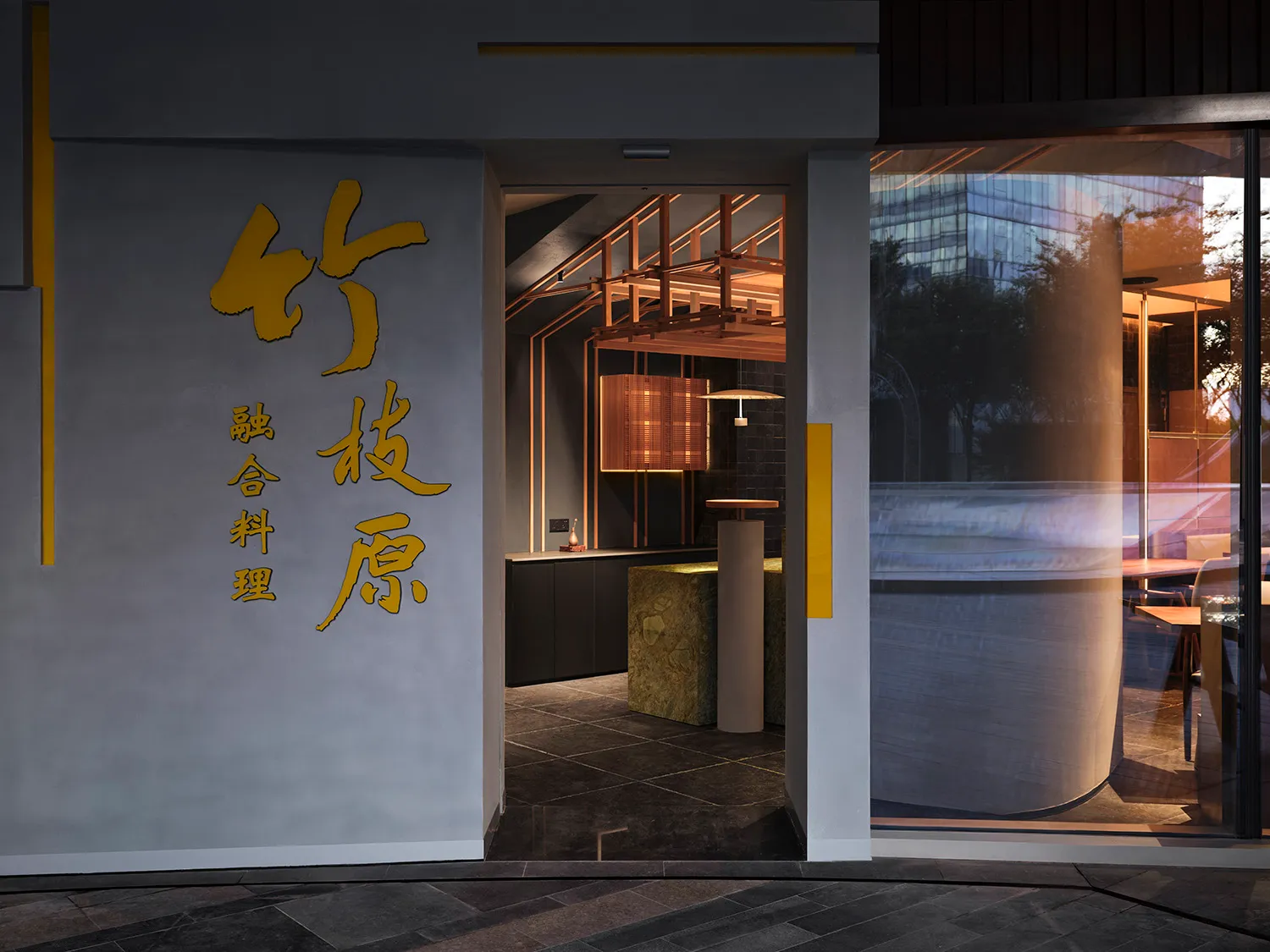 A modern Asian restaurant with a large window, two dining tables, and a vase, creating an inviting and comfortable atmosphere