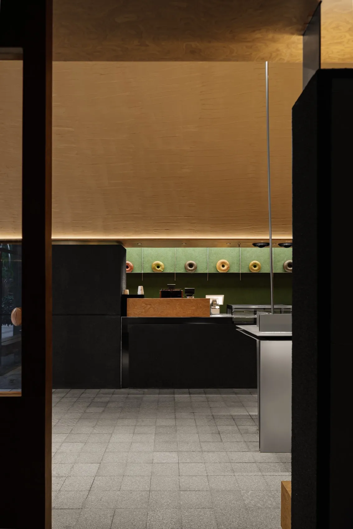 Office space with wooden floors and walls, featuring a countertop with three donuts, conveying a calm and organized atmosphere