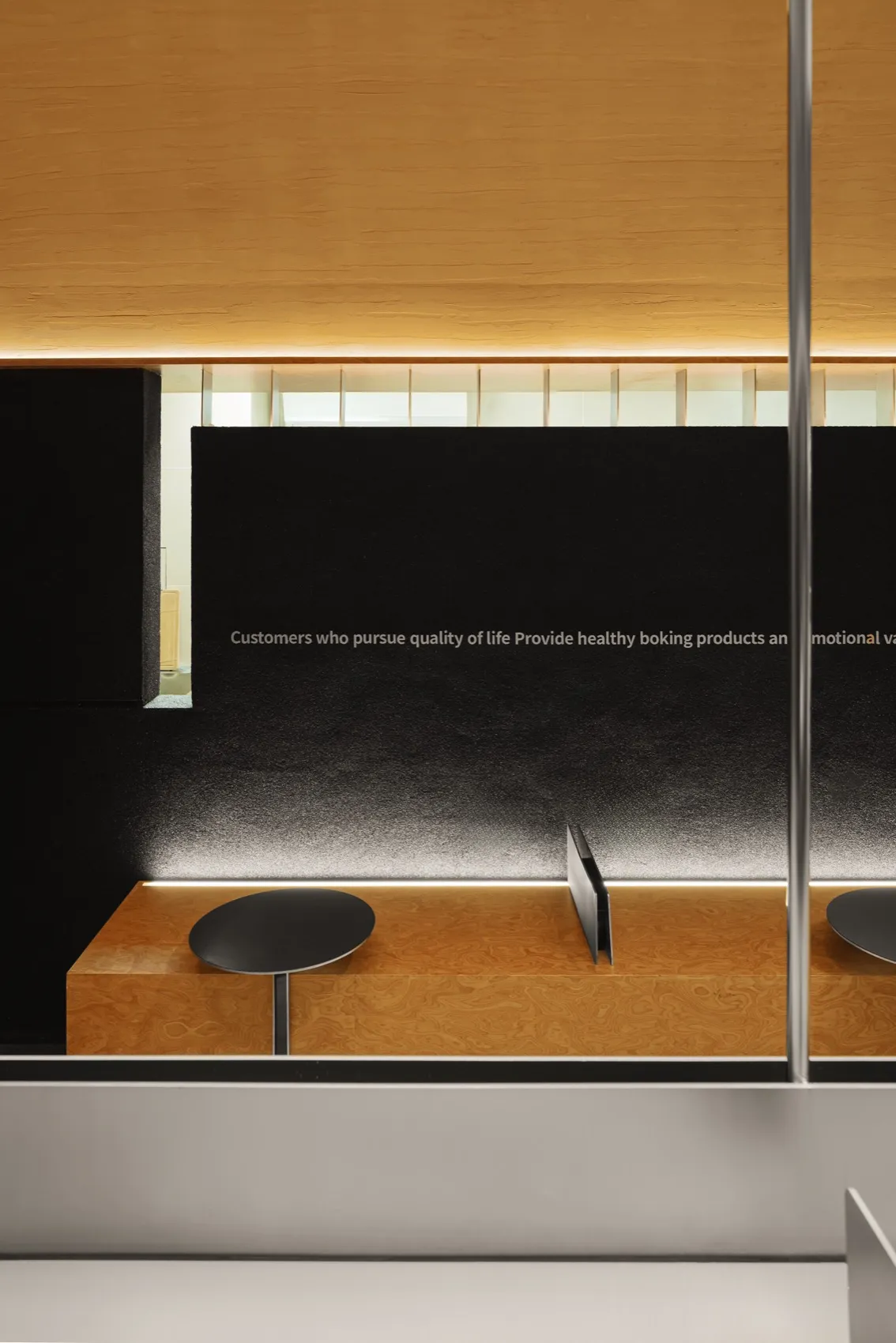 Modern cafe interior with a wooden countertop, two stools, and two dining tables, featuring a sleek and functional design