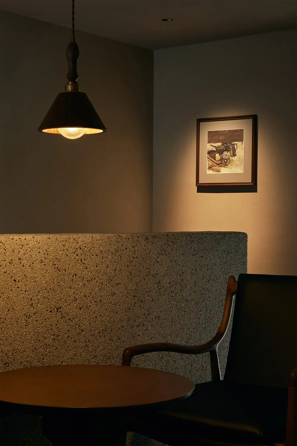 Dimly lit room with two chairs and stone-like walls creating a cozy atmosphere