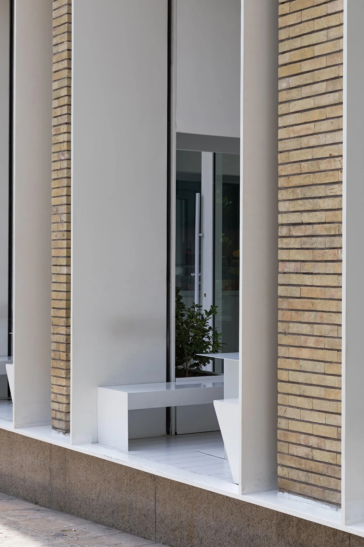 A brick building facade with three benches in front, creating a calm and inviting atmosphere
