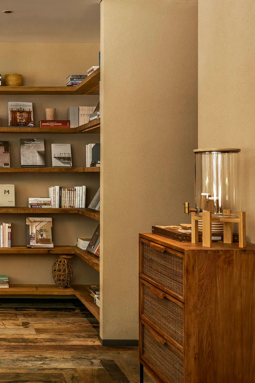 A wooden bookshelf filled with various books in different sizes and colors, creating a cozy and intellectual environment