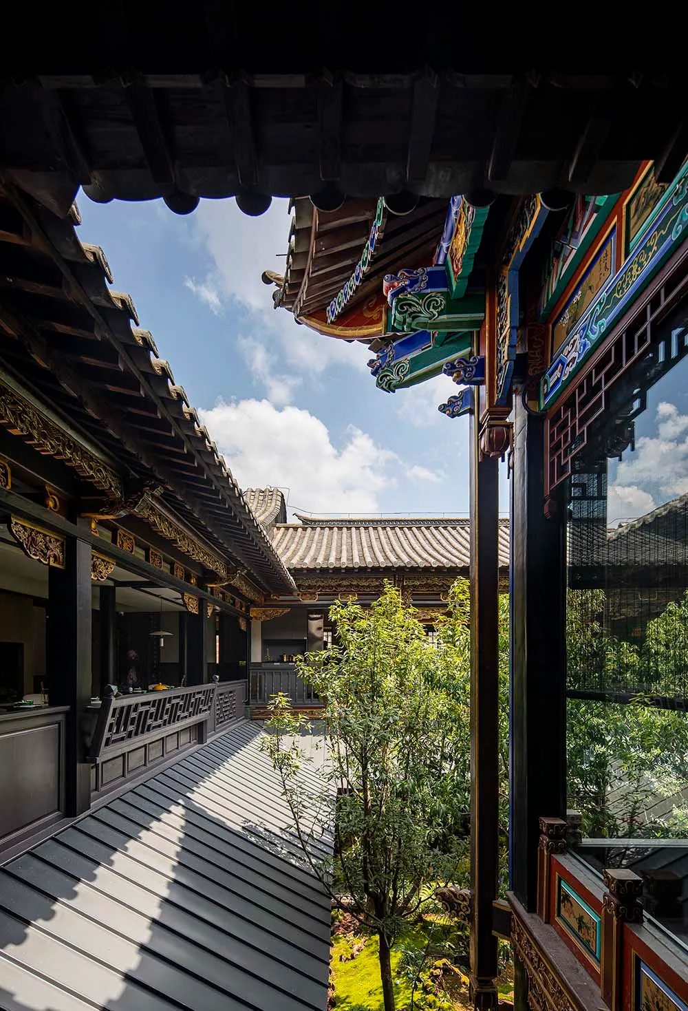 A real photo of an Asian-style building with a large roof and intricate details on its facade, featuring a courtyard surrounded by various structures with a mix of traditional and modern elements, natural light, and a sense of harmony between tradition and contemporary design