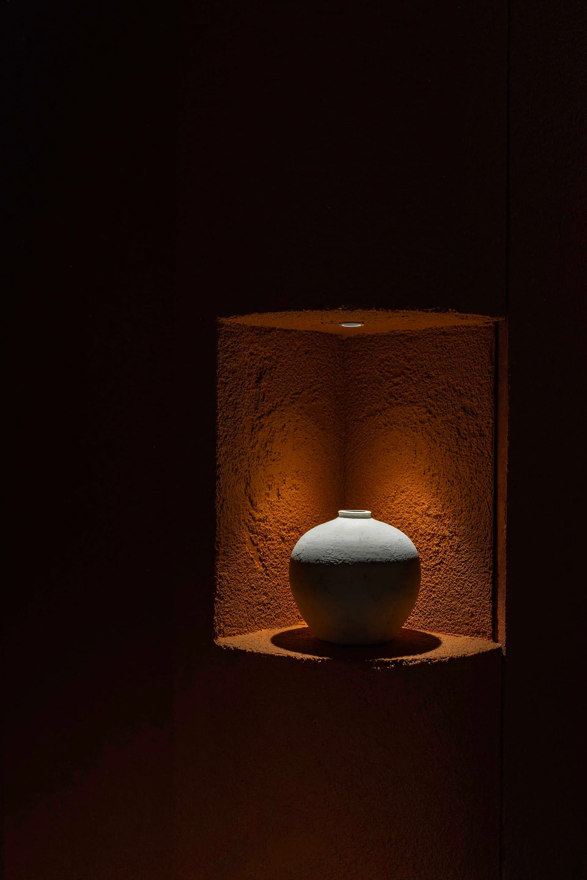 A cozy home interior with a ceramic vase on a brown surface, suggesting a warm and inviting atmosphere