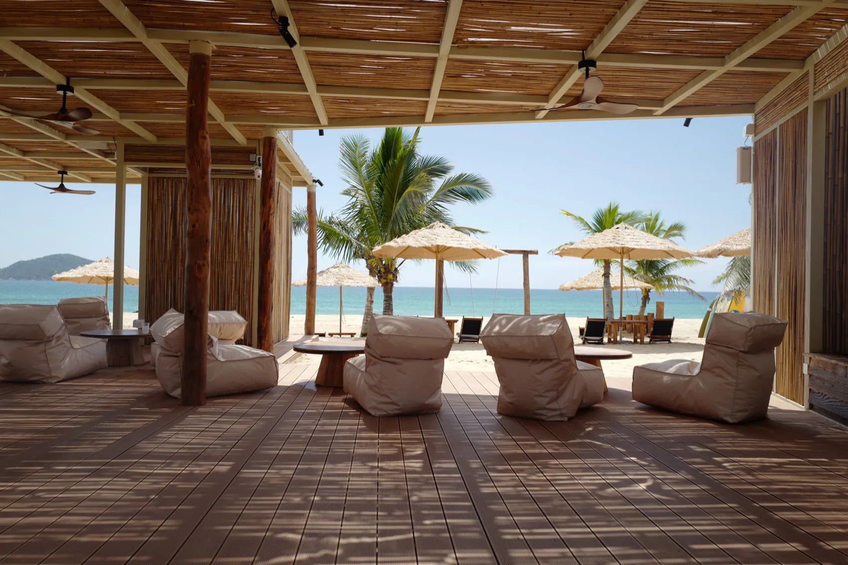 A relaxing beachside patio with chairs and umbrellas, surrounded by a scenic beach view