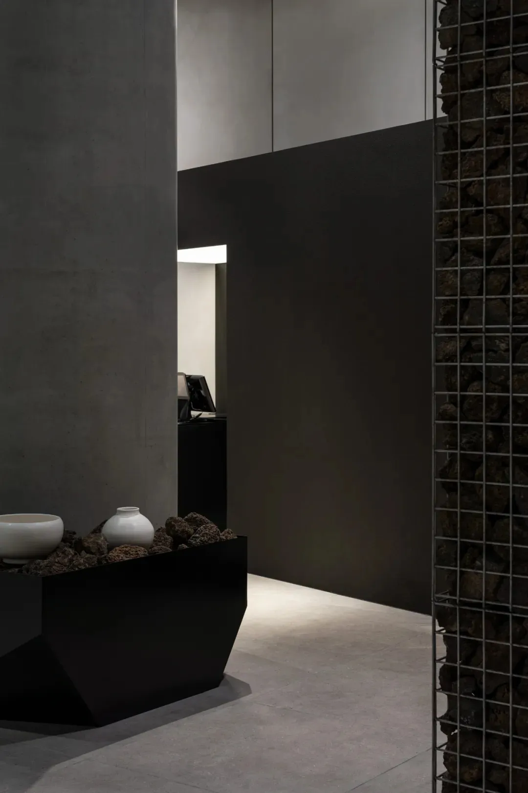 A modern hallway with white walls, a doorway, and decorative vases and a bowl, set against a neutral background