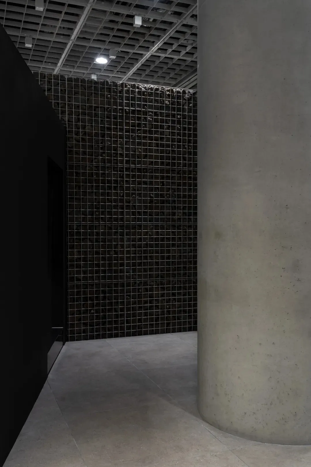 Exposed brick wall with a unique pattern, dimly lit space with a focus on functionality