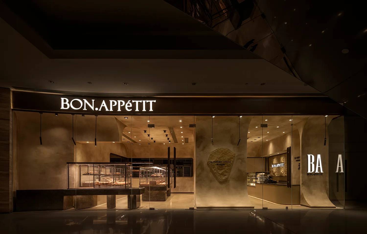 A well-lit restaurant interior with stone and wood walls, tables, and chairs, creating a warm and inviting atmosphere