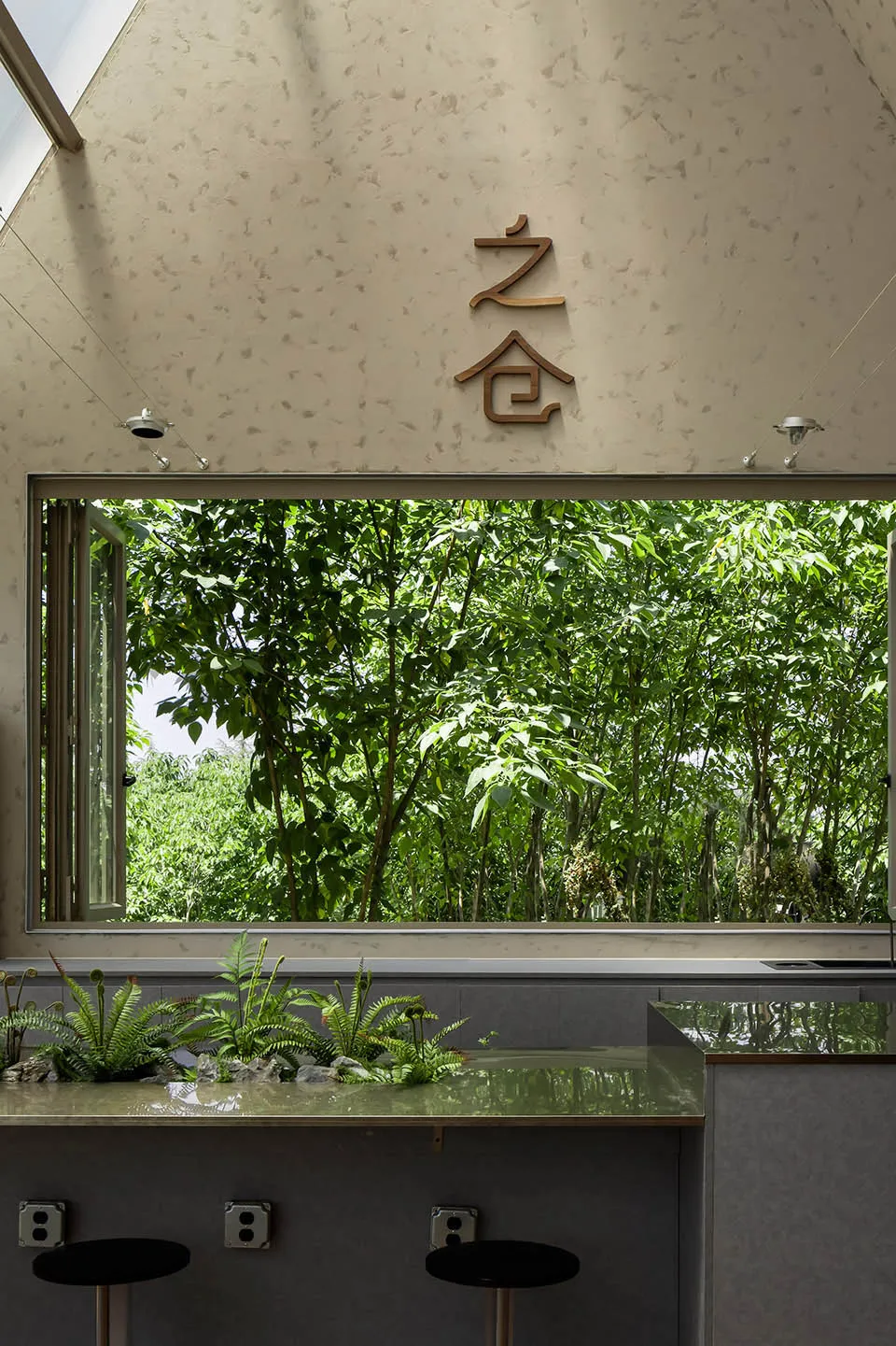 亞洲風格浴室，配有大窗戶、水槽區和盆栽植物，充滿自然光線與寧靜氛圍
