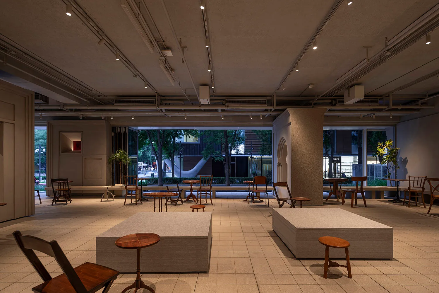 A modern living-dining space with multiple chairs, a large window, and a bright atmosphere, suitable for gatherings or social events