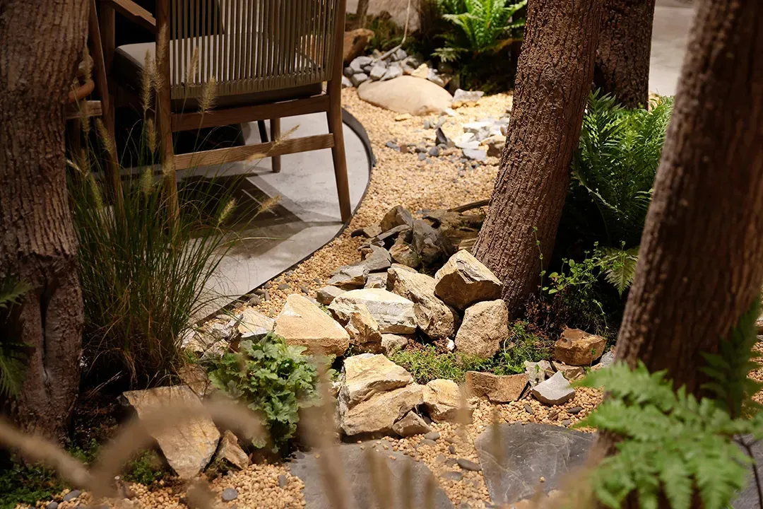 Cozy indoor space with a rock garden, multiple chairs, and potted plants, creating a relaxing atmosphere