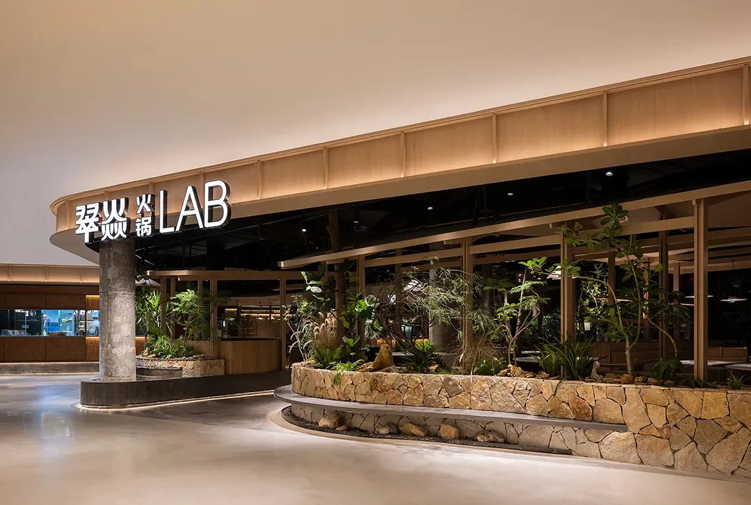 A cozy indoor space with potted plants, dining tables, and chairs, creating a welcoming atmosphere for customers