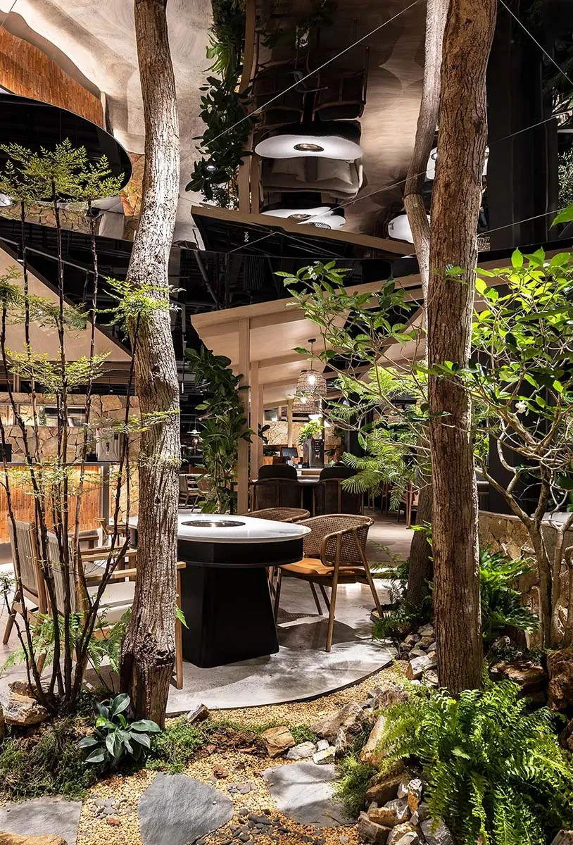 A cozy restaurant seating area with chairs, a dining table, and potted plants, creating a warm and inviting atmosphere