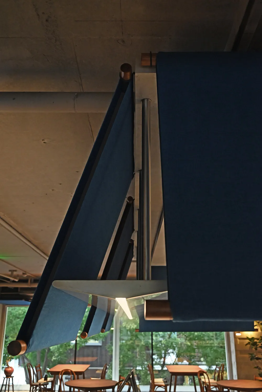 A room with fabric curtains hanging over a table, creating a cozy atmosphere with a window in the background