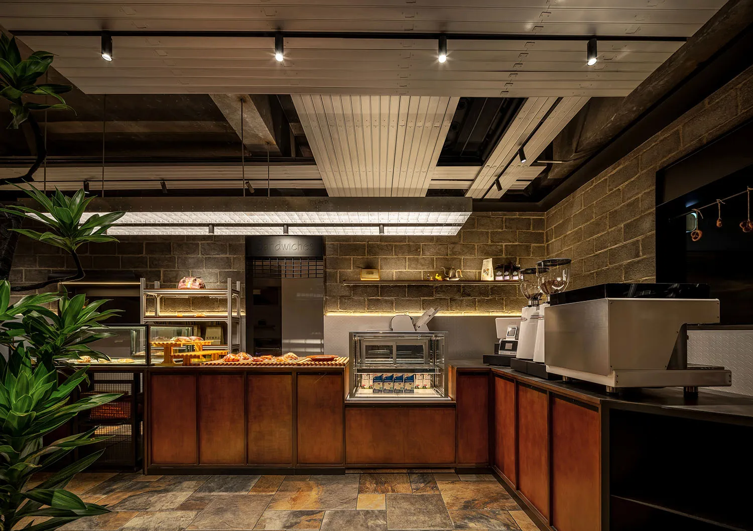 Industrial kitchen with a counter featuring food items, sinks, and a potted plant, set against a rendered background