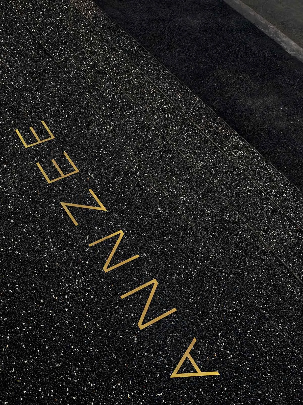 A modern sign with black and gold lettering on a black background, possibly a floor plan or architectural design