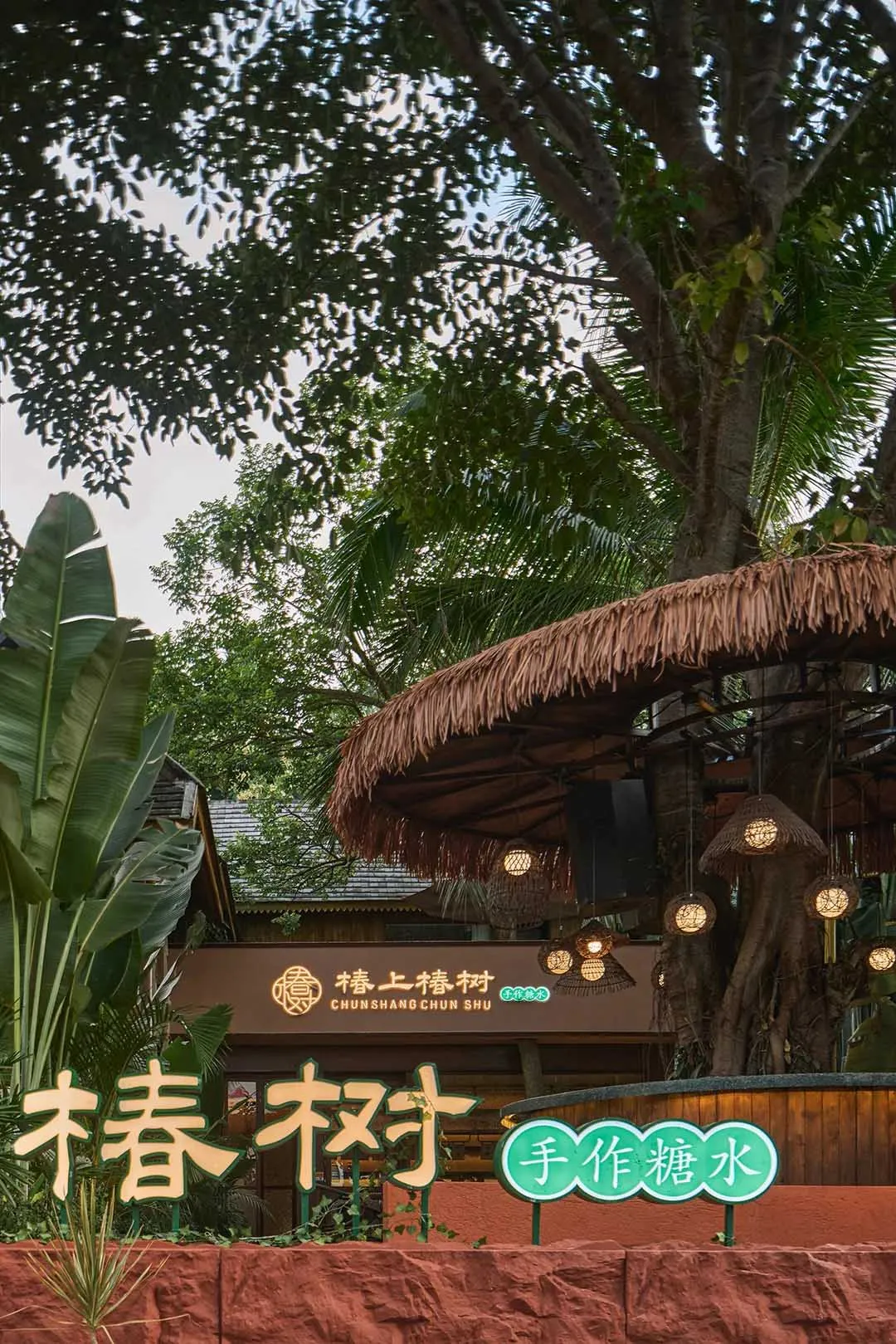 Warm and inviting Asian restaurant with a thatched roof, comfortable seating, and lush greenery