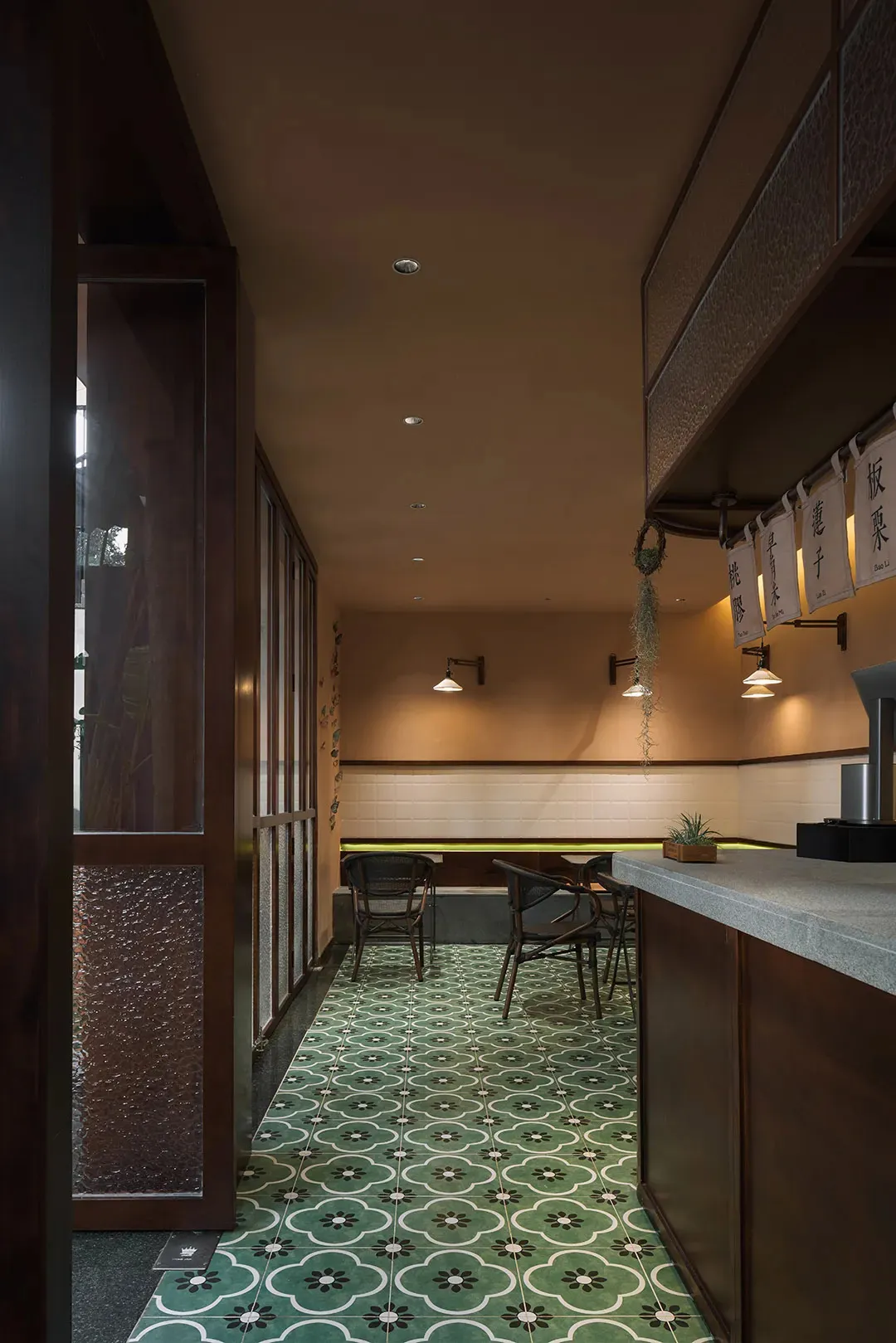 Warm and inviting restaurant interior with beige walls, potted plants, and a dining area with tables and chairs