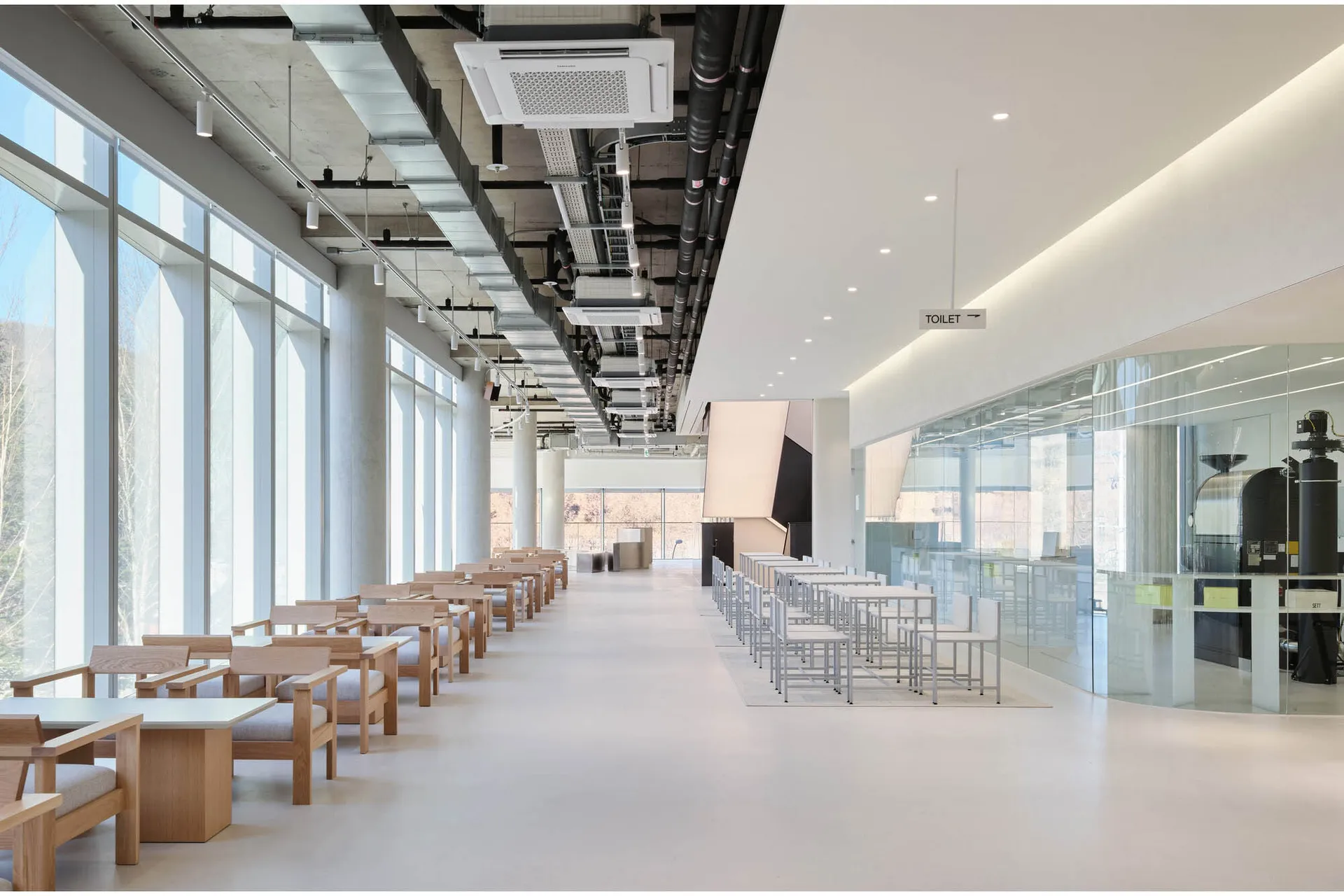 Empty office space with large windows, tables, and chairs, creating a clean and inviting atmosphere