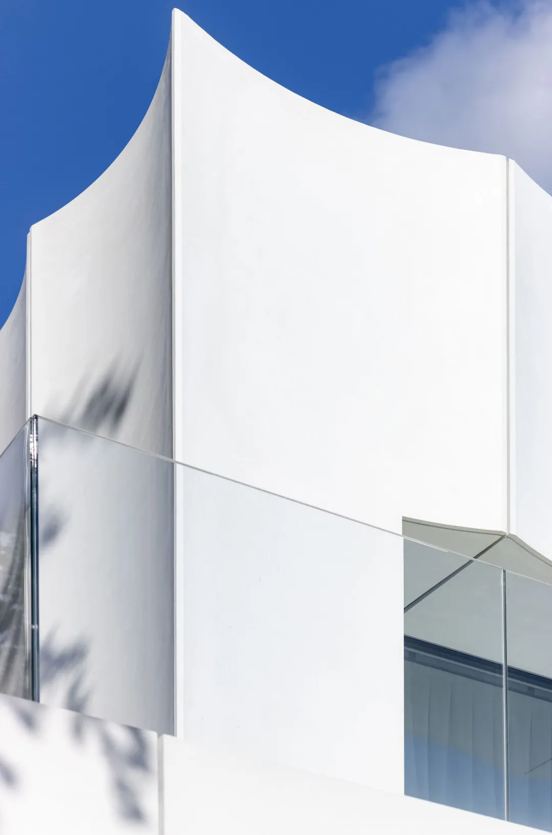 A modern building with a curved wall, large windows, and a minimalist design